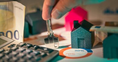 hand holding key over house models