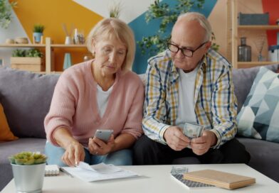 Elderly couple looking at bills and phone