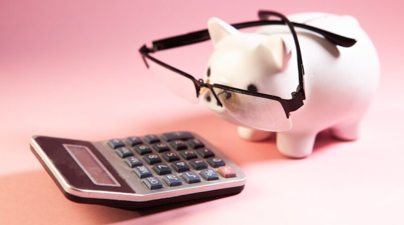 A piggy bank wearing glasses next to a calculator