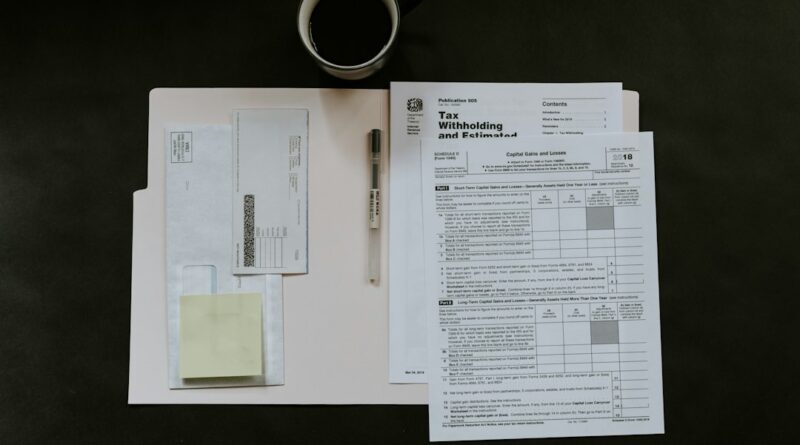 Tax forms, a pen, and a coffee mug on a dark desk